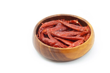 Dried pepper chillies in wooden bowl on white background.
