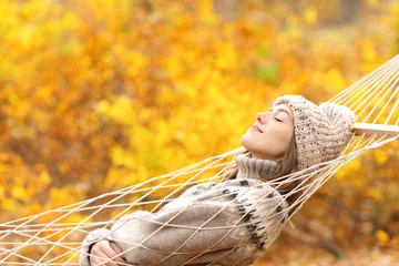 Poster Woman sleeping on hammock in a forest in autumn © PheelingsMedia