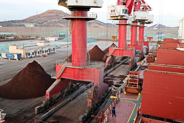 Cargo terminal for unloading bulk cargo of iron ore by shore cranes and grabs. Huludao, China,...