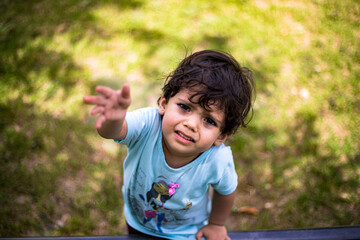 little indian baby girl playing in green garden in summer.