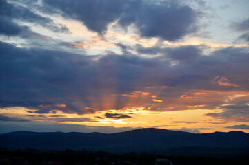 colorful cloudy sunset sky over the hill