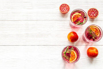 Naklejka na ściany i meble Glasses of cranberry lemonade and red oranges with rosemary