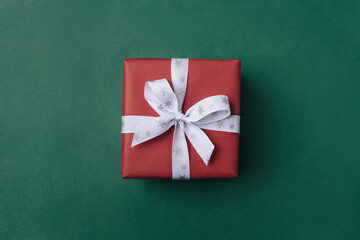 Gift boxe with white bow on a green backdrop.