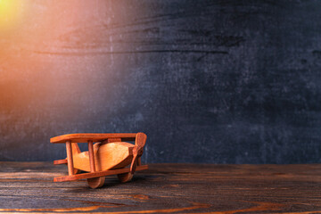 wooden toy airplane on the background of a chalk board. Small biplane made of wood on a dark...
