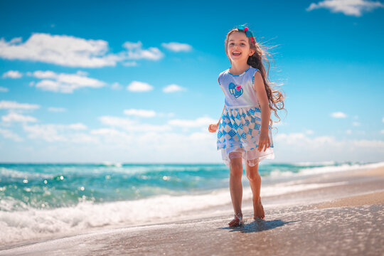 Happy girl running on tropical beach on summer holidays
