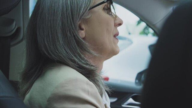 Mature woman driver feels pain in neck and shoulders because of air conditioning