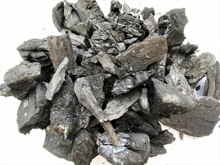 Natural charcoal isolated on white background. Heap of natural broken black activated charcoal. Lots of big and small pieces Top view.
