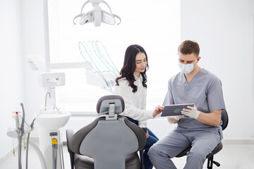 Male dentist with digital tablet. Modern treatment in professional dental clinic.