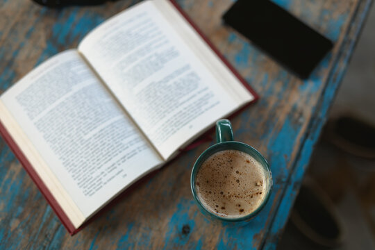 Open book and cup of coffee on the table