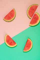  Slices of fresh watermelon on pink and green background.Flat lay with copy space.Trendy food photography.
