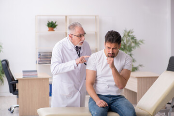 Obraz premium Young male patient visiting old male doctor