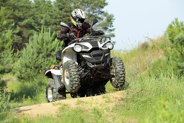 Man driving modern quad bike on sandy road near forest. Extreme sport © New Africa