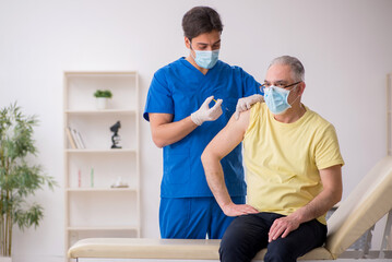 Obraz premium Old male patient visting young male doctor in vaccination concep