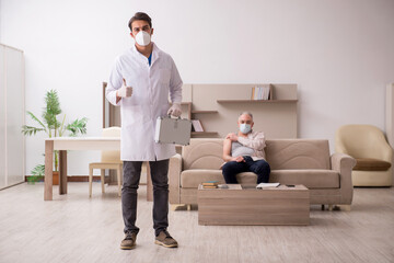 Young male doctor visiting old patient in vaccination concept