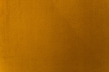Gold or brown paint on cement wall texture as background