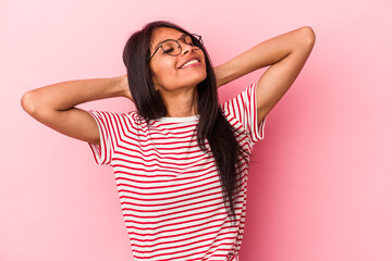 Young latin woman isolated on pink background feeling confident, with hands behind the head.