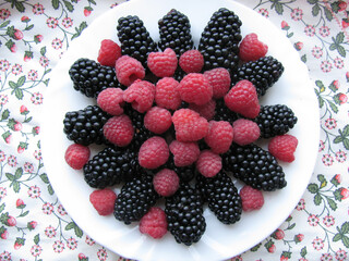 Freshly picked ripe raspberries and blackberry on the plate