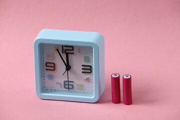 Alarm clock with aa batteries on a pink background