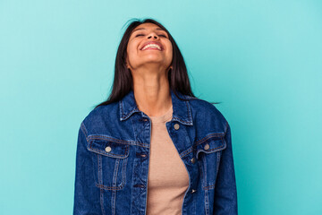 Young latin woman isolated on blue background relaxed and happy laughing, neck stretched showing teeth.