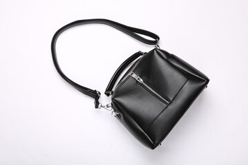 Fashionable leather black handbag on white background. Top view
