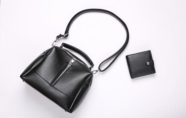 Fashionable leather black bag and purse on white background. Top view. Flat lay