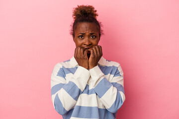 Young african american woman isolated on pink background biting fingernails, nervous and very anxious.