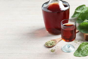 Broadleaf plantain tincture on white wooden table, space for text