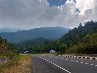 wide highway and blue sky and white clouds and mountains background
