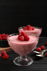 Delicious raspberry mousse on black wooden table