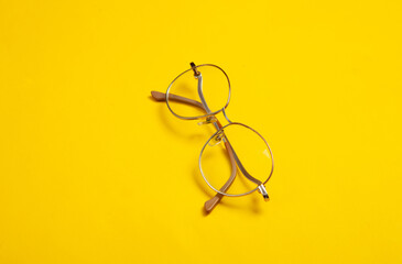 Optical eye glasses on yellow background