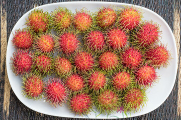School rambutans are ripening, red to be appetizing.