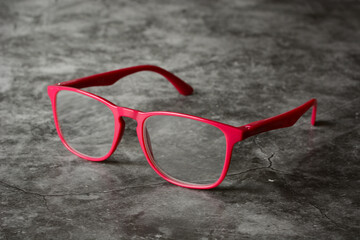 glasses fuchsia color on the gray background - close up