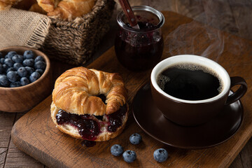 Croissant with blueberry jam and coffee