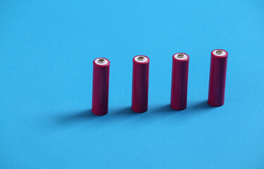 Four pink AA batteries on blue background.