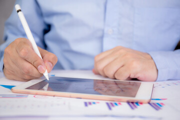 Businessman planning about graph and chart of investment with report for finance on tablet computer on desk, statistic for financial and profit with document, digital marketing, business concept.