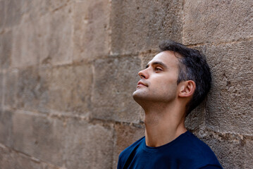 Fototapeta premium Young latin thoughtful man against a wall outdoors