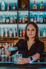 Portrait of young attractive woman bartender Making Cocktail in bar