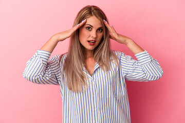 Young russian woman isolated on pink background celebrating a victory or success, he is surprised and shocked.