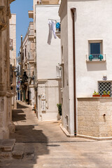wąska uliczka miedzy kamienicami z białego kamienia, Monopoli, Puglia, Włochy 