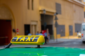 Taxi sign on the roof of a car in a street