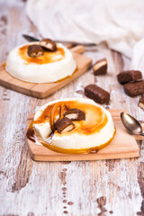 Vanilla panna cotta with caramel on wooden rustic table