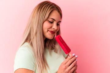 Young russian woman holding an ice cream isolated on pink background