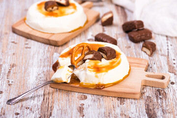 Vanilla panna cotta with caramel on wooden rustic table