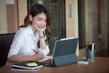 Portrait of Beautiful businesswoman sitting at desk and working with laptop computer.