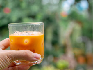 glass of delicious ice thai tea in hand