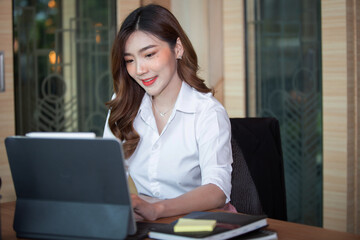 Portrait of Beautiful businesswoman sitting at desk and working with laptop computer.