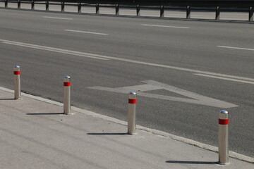 metal posts on the sidewalk along the road