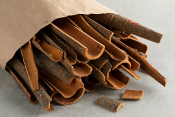 Paper bag with dried cassia cinnamon bark pieces close up   