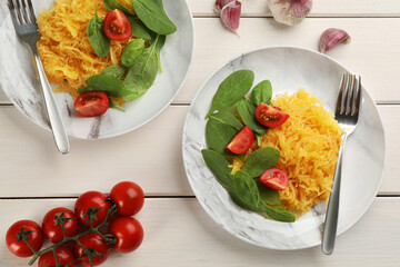 Tasty spaghetti squash with tomatoes and basil served on white wooden table, flat lay