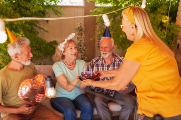 Senior people throwing a surprise birthday party for a friend